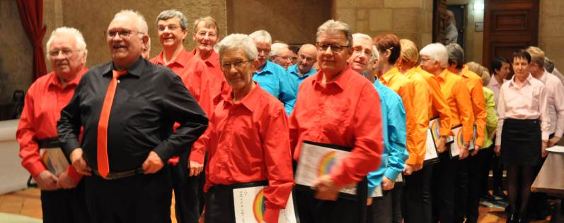 La chorale Arc-en-ciel emmenée par son chef Roger Ribeyron se prépare à entrer sur scène